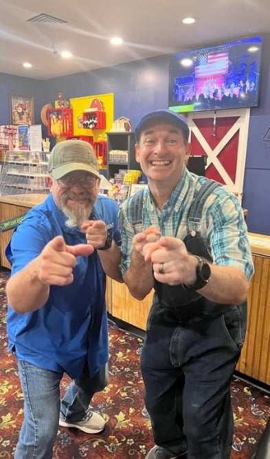 2 men looking at camera with smiles.