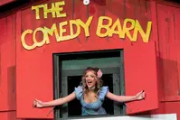 performer popping out of a window at The Comedy Barn